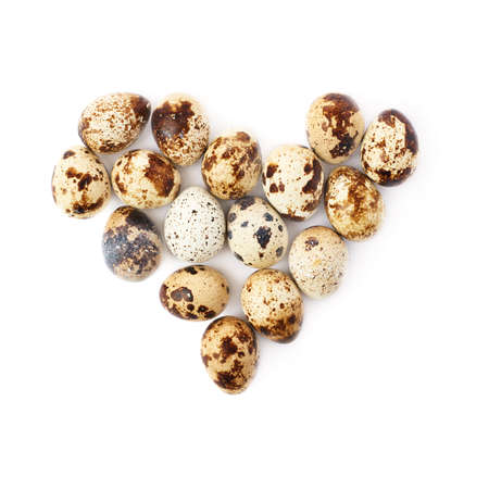 Heart shape made of quail eggs isolated over white backgroundの写真素材