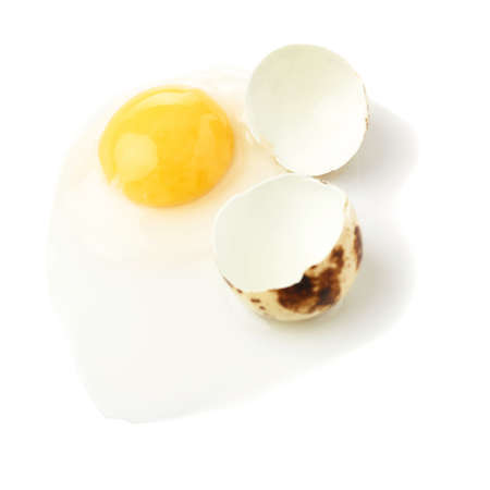 Single cracked raw quail egg with yolk isolated over white backgroundの写真素材