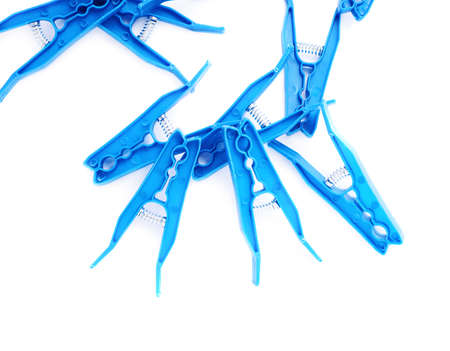 Pile of blue plastic cloth pegs isolated over white backgroundの写真素材