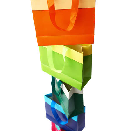 Tower stack of colorful shopping or gift bags isolated over the white backgroundの写真素材