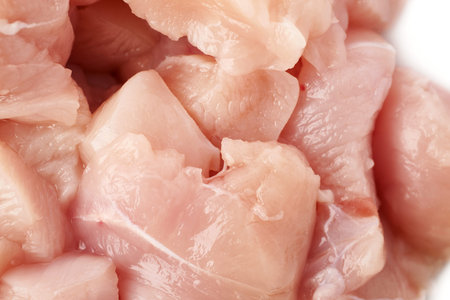 Raw chicken fillet breast cut into pieces isolated over white backgroundの写真素材