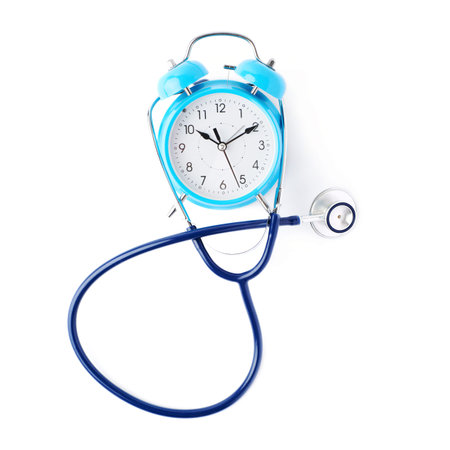 Close up view of blue stethoscope with alarm clock over isolated white background
