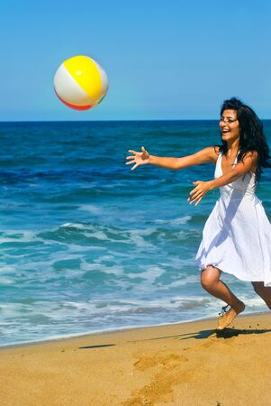 Girl is playing with ball at the beachの写真素材