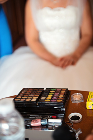 Beautiful bride applying wedding make-up by professional make-up artist on the wedding dayの写真素材