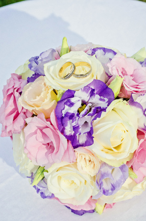 Yellow pink and purple wedding bouquet from roses. Beach and sea backgroundの写真素材