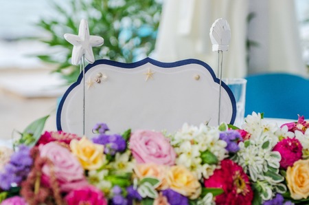 A white card Just married sign on table with flowers at a beach weddingの写真素材