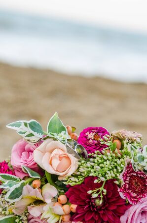 Colorful wedding bouquet from roses. Pink, red and green colors. Beach wedding.の写真素材