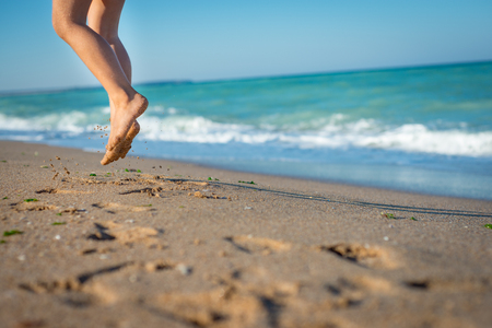Child is jumping on the beach. Sand and sea in Bulgaria, Europa.の写真素材
