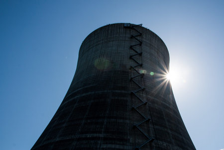 Nuclear cooling tower under a blue sky with a sunburstの写真素材
