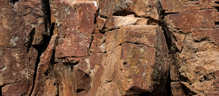 Red desert rocky hillside with rough cracked stones.の写真素材