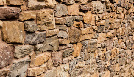 Irregular red, orange stone wall backgroundの写真素材