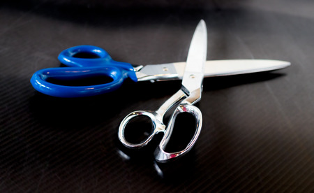 Stainless steel shears crossed on a carbon fiber tableの写真素材