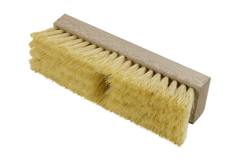Wooden push broom head with yellow bristles on a white backgroundの写真素材