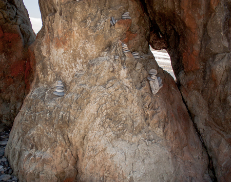 Small flat stones stacked in a rock formation at the beach in a coveの写真素材