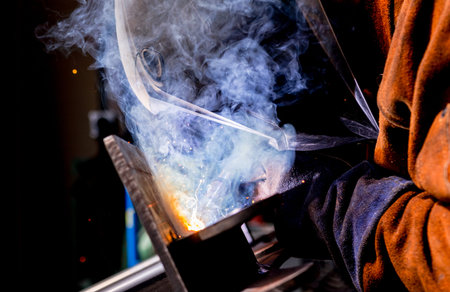 Man tig welding steel iron plates with brilliant bright white star burst bloom of lights