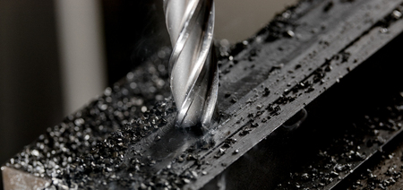 Bridgeport CNC end mill finishing a stack of steel plate with metal filings chipsの写真素材