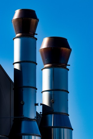 Industrial external air ventilation duct exhaust vents with a blue skyの写真素材