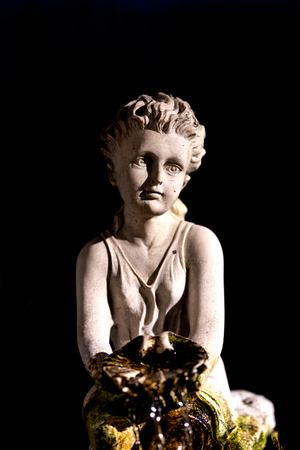 White garden statue isolated on black backgroundの写真素材