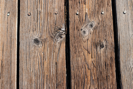 Aged wooden planks nailed to a boardwalk with knotsの写真素材