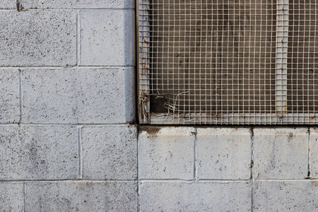 Old rocky wall with chain grated window holeの写真素材