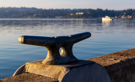 Morning sunrise harbor dock cleat with hazy filtered light and shadowsの写真素材