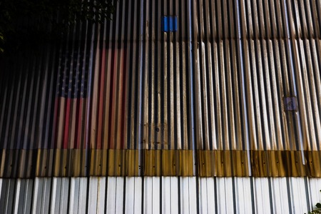 Dirty rusty building wall with american flag in daylightの写真素材
