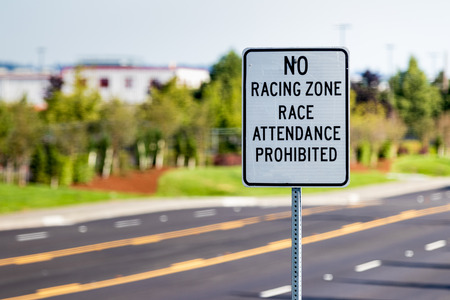 No racing zone sign on a post with a streetの写真素材