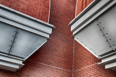 Abstract modern brick building corner with steel flutes in daylightの写真素材