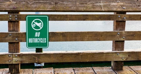 No motorcycles sign on a wooden rail fence in daylightの写真素材