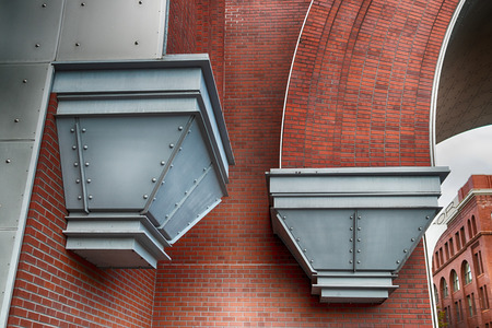 Abstract modern brick building corner with steel flutes in daylightの写真素材