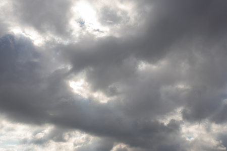 Heavy dark clouds with sunlight highlights and deep shadowsの写真素材