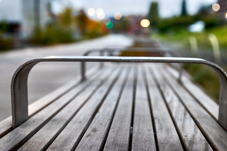 City park bench with buildings and shallow depth of fieldの写真素材