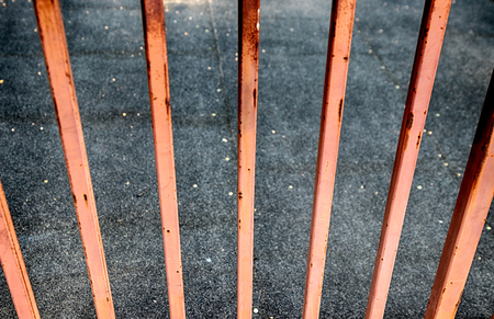 Abstract rusty fence looking over concrete city walkwayの写真素材