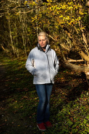 Attractive blonde woman walking in the forest on a nature hikeの写真素材