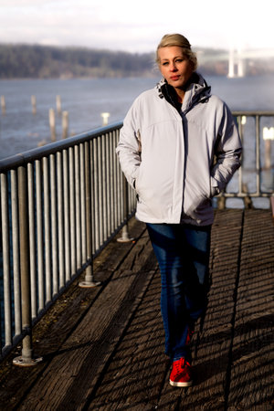 Attractive blonde woman walking along the waterfront