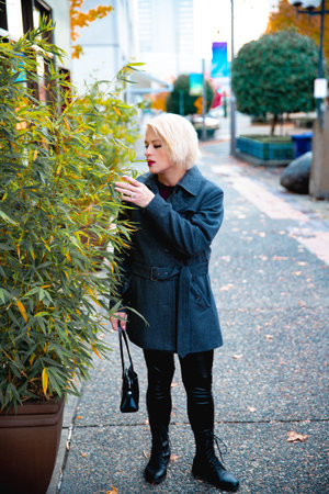 Fashionable blonde woman walking exploring the cityの写真素材