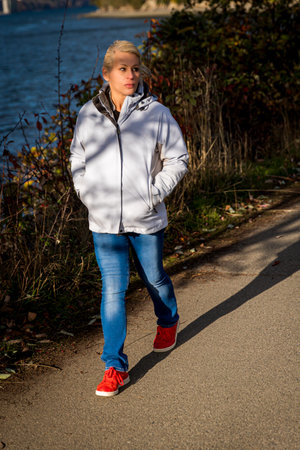 Attractive blonde woman walking along the waterfrontの写真素材