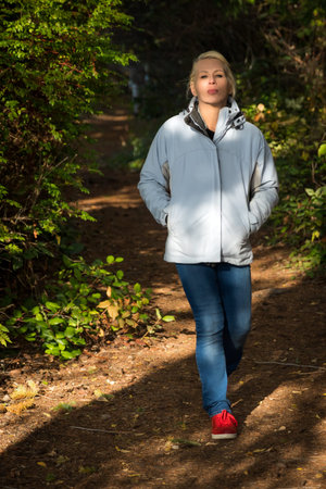 Attractive blonde woman walking in the forest on a nature hike