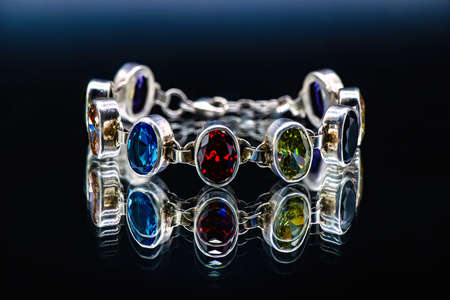 Silver bracelet with color jems dark isolated background reflection light antiques Jewelryの写真素材