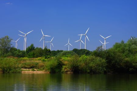 The windmills among trees after second side of lakeの写真素材