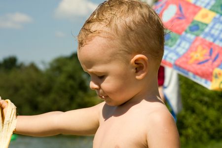 Small boy over the lake during the rest eat bananaの写真素材
