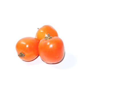 Close up view bunch orange tomatoes isolated on withe background with clipping. Group of fresh orange tomatoes isolated on white backgroundの写真素材