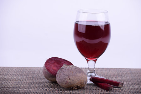 Beet juice served in a wine glass in the center on the right side