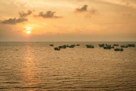 Fishing boat heading towards the day to day fishing in the sunrise hours. Image taken from high angle showing the orange light of the sun and beautiful horizon.の写真素材