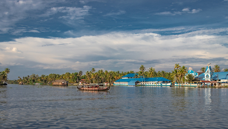 blue church on the edge of alleppey backwater with houseboats trail and palm tree giving the real feeling of nature with God.の写真素材