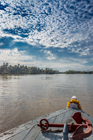 Red Boat anchor on boat in blue sky backwater fill with lots of cloud backgroundの写真素材