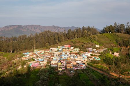 small village on hill top with green forest of western ghat image is taken at ooty tamilnadu showing its beautiful landscape. it is showing the different color in different time of the day.の写真素材