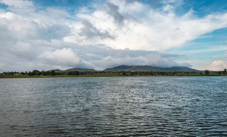 beautiful lake with mountain and amazing sky background image is showing the amazing beauty and art of nature. This image is taken at karnataka india from hilltop.の写真素材