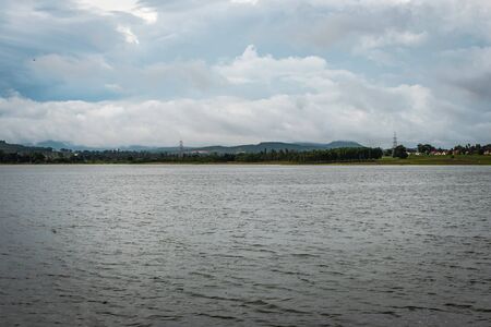 beautiful lake by the side of road with mountain and amazing sky backgroundの写真素材