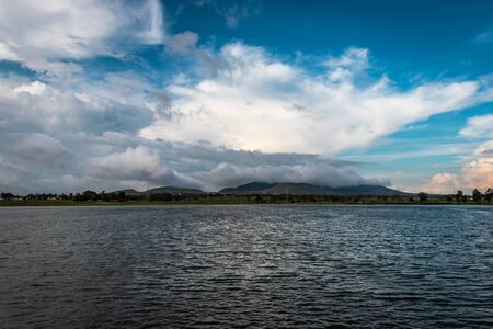 beautiful lake by the side of road with mountain and amazing sky backgroundの写真素材
